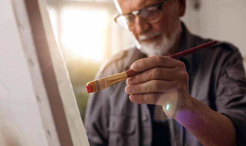 senior-living-man-painting-luxury-apartment-minneapolis-elmwood senior-living-man-painting-luxury-apartment-minneapolis-elmwood